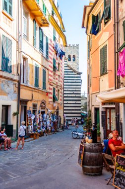 İnsanlar Monterosso Al Mare, Cinque Terre, İtalya 'nın rahat sokaklarında restoran ve barlarda oturuyorlar.