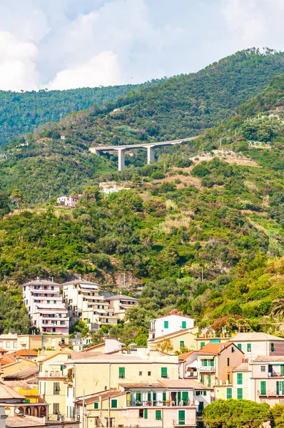 El famoso paisaje y paisaje urbano de Monterosso Al Mare con verdes montañas puente alto y edificios tradicionales de la ciudad . — Foto de Stock