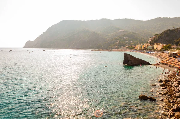 A famosa praia cheia de espreguiçadeiras, guarda-sóis, banhos de sol e turistas de natação em Monterosso Al Mare, Cinque Terre, Itália — Fotografia de Stock