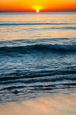 Gün batımı güneşi ufukta batıyor. Günbatımında arkasında Elba adası olan Tyrhenian Deniz Koyu. Cala Violina Sahili