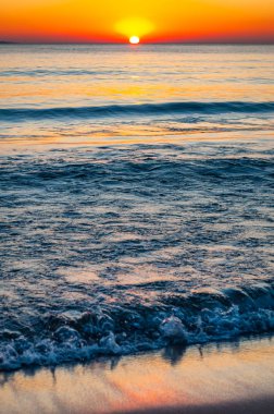 Gün batımı güneşi ufukta batıyor. Günbatımında arkasında Elba adası olan Tyrhenian Deniz Koyu. Cala Violina Sahili