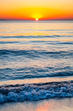 Gün batımı güneşi ufukta batıyor. Günbatımında arkasında Elba adası olan Tyrhenian Deniz Koyu. Cala Violina Sahili