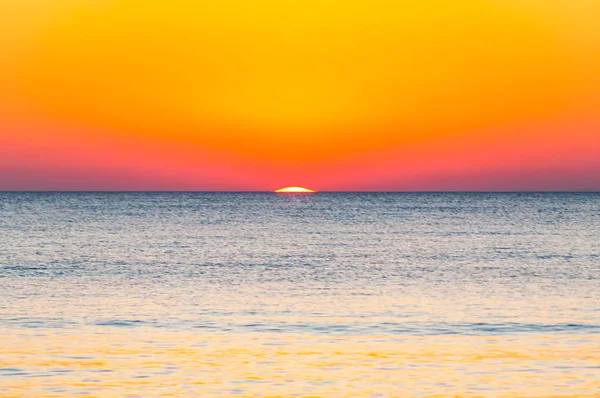 Los últimos segundos del increíble atardecer detrás del horizonte marino. Un poco de la esfera de estrellas del sol que se muestra por encima del nivel del mar Tirreno. Puesta de sol vibrante en la playa de Cala Violina — Foto de Stock