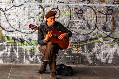 Londra, Birleşik Krallık - 14 Eylül 2017: Müzisyen oturma ve klasik gitar çalma Duvarı ile dolu sokakta