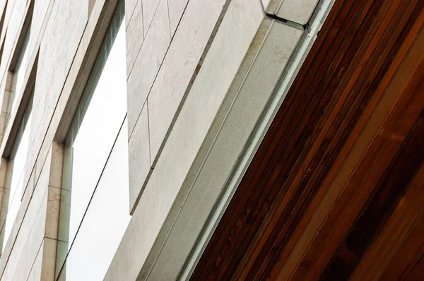 Modern facade cladding with stone and ceiling paneling with wood