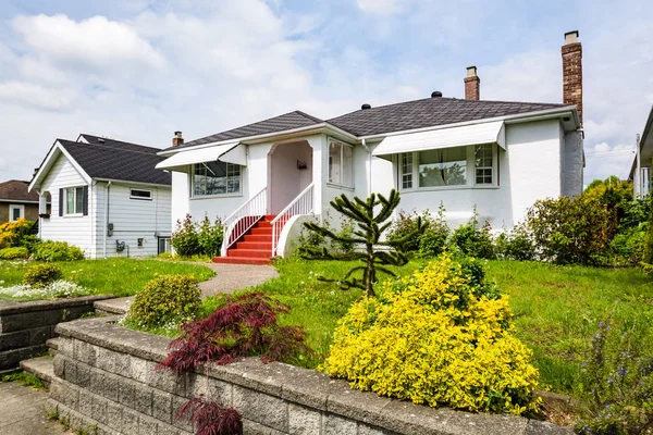 Residential house with concrete pathway over the front yard on cloudy day — Stock Photo, Image