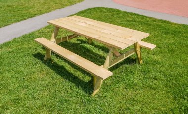 Bir parkta yeşil çim üzerinde piknik masası ile küçük rekreasyon alanı