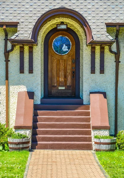 Stylish arch exterior door, wooden door of a house with mosaic glass sections.
