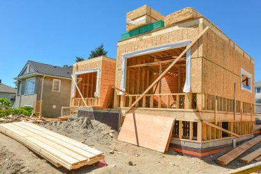 Üst te 2x4 ahşap panoları yığınları ile yapım aşamasında yeni aile evi