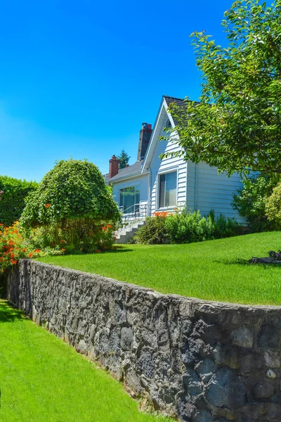 Haus auf Landterrasse mit schönem Rasen. — Stockfoto