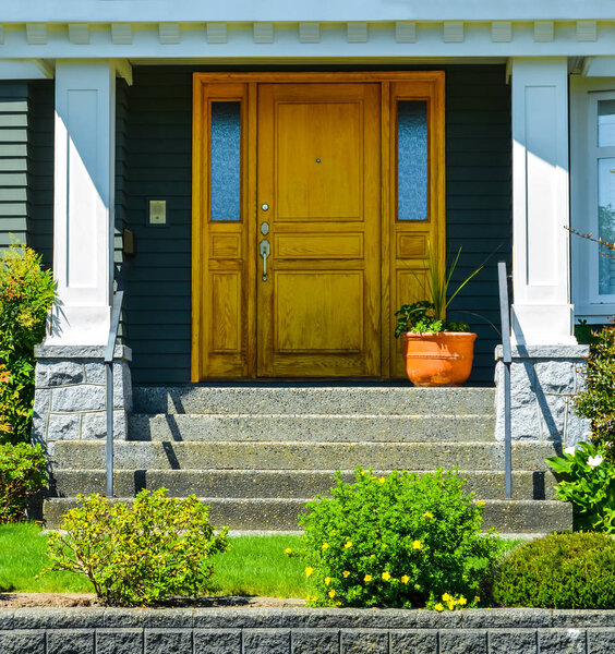 Doorsteps to the entrance of family house with landscaped front yard