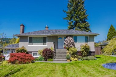 Bahçede çiçek açan çiçekleri olan mütevazı aile evi