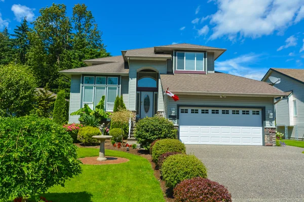 Житловий будинок з Канадським прапором на вході і декороване подвір'я — стокове фото