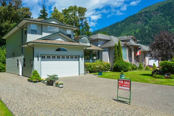 Casa de subúrbio com vista para a montanha e fundo azul céu para venda — Fotografia de Stock