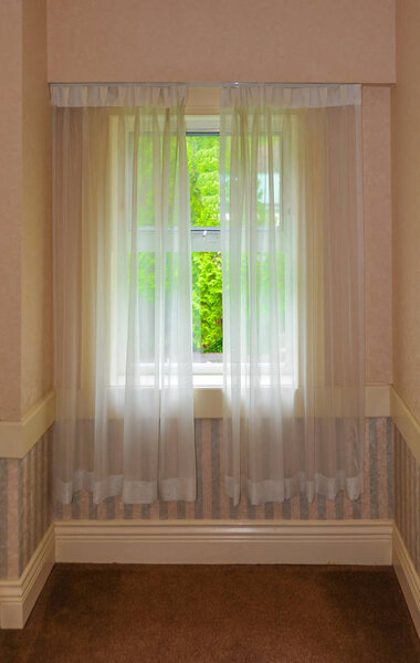 Semi transparent valance on a window in a house.