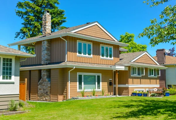 Average family house with big green lawn in front on blue sky background — Stock Photo, Image