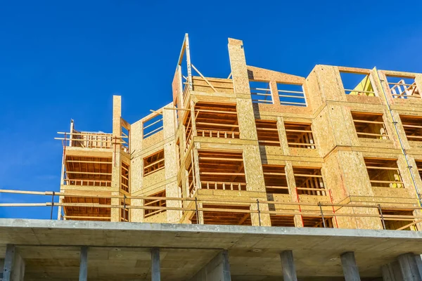 New low-rise building up on concrete base of first level on sunny day