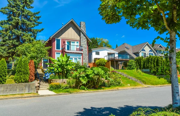 Belle maison de banlieue avec terrasses paysagées et fond bleu ciel — Photo