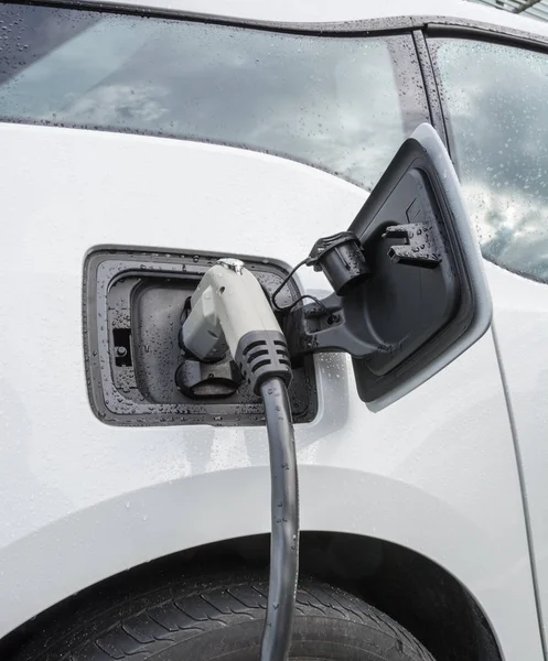 Electric vehicle with the power plug connected to the car