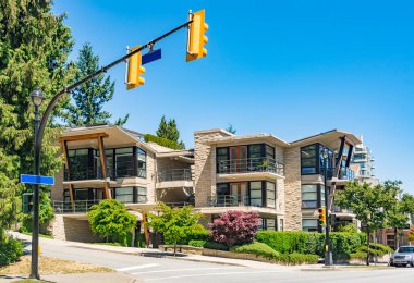 Güneşli bir günde sokakta park edilmiş araba ile yepyeni bir apartman