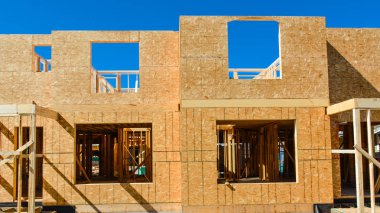 Mavi gökyüzü arka planda yeni düşük katlı binanın pencere çerçevesi.