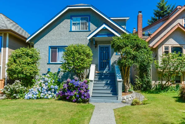 Жилой дом с дорожкой на лужайке перед домом на голубом фоне неба — стоковое фото