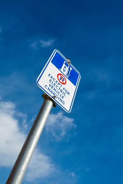 Ev - Ladestationsschild für Elektrofahrzeuge auf blauem Himmel — Stockfoto