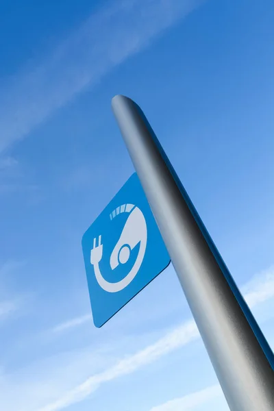 EV - señal de la estación de carga rápida del vehículo eléctrico en el fondo azul del cielo —  Fotos de Stock