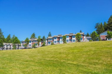 British Columbia güneşli bir günde tepenin üstünde yeni townhouses Satır.