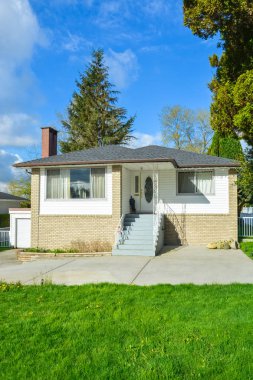 Önünde garaj ve beton driveway ile Mütevazı beyaz tuğla aile evi