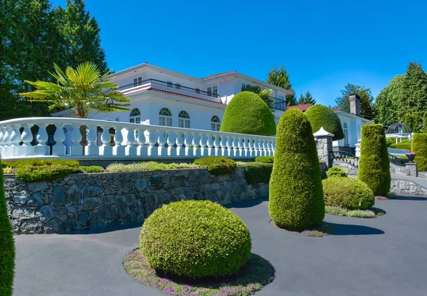 Arazi terası üzerine inşa edilmiş beyaz korkuluk ile çitle çevrili lüks konut evi