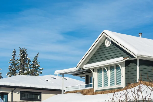 Top domu mieszkalnego w śniegu w słoneczny zimowy dzień w Kanadzie. — Zdjęcie stockowe