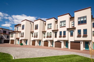 Mavi gökyüzü arka planda önünde park yeri ile townhouses Satır