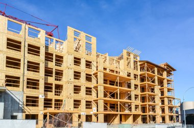 Mavi gökyüzü arka plan üzerinde kırmızı vinç ile Konut apartman