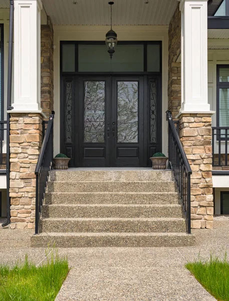 Huvudingången till bostadshus med dörr steg och blomkrukor vid dörren Stockbild