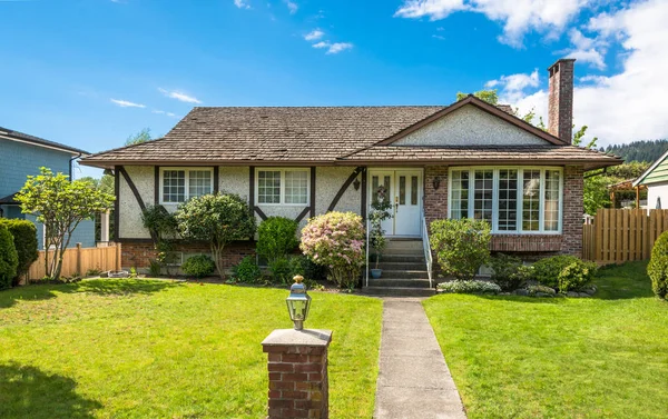 Casa unifamiliare con prato verde di fronte su sfondo cielo blu . — Foto Stock