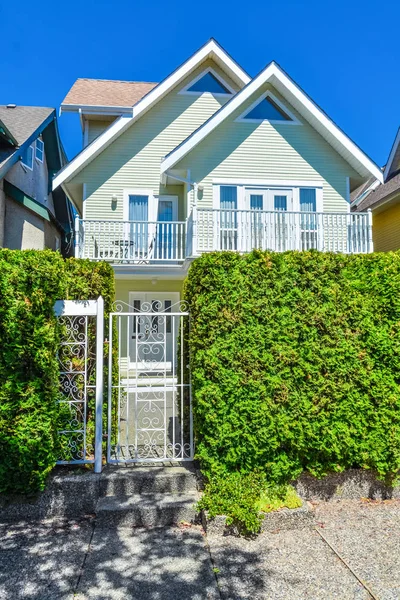 Maison résidentielle avec portail d'entrée et haie verte devant . — Photo