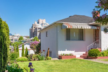 Güneşli bir günde evin ön bahçesi ve girişi.