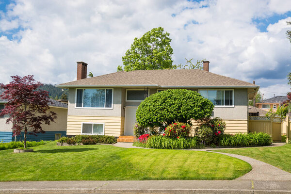 Average North American family house on cloudy sky background.
