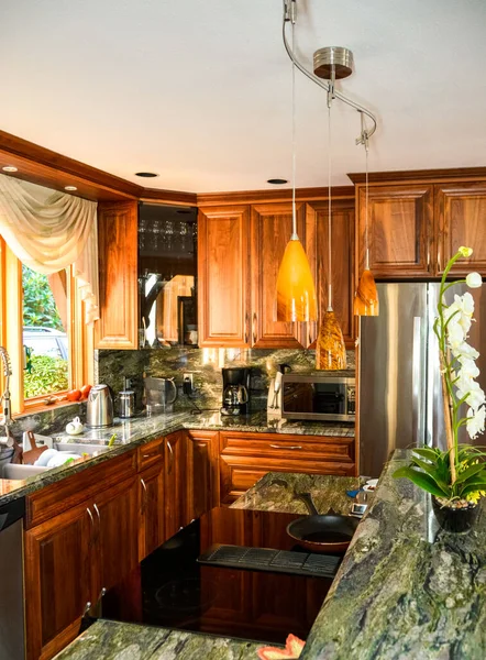 Elegante cozinha interior de madeira com fogão de cerâmica na mesa da ilha . — Fotografia de Stock