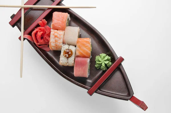 吃沙片寿司的特写，用筷子和大豆放在服务船托盘上 — 图库照片