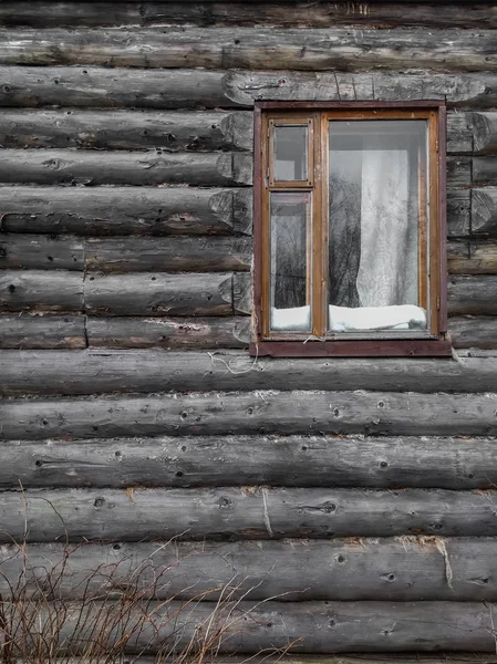 在窗口背景的木制的墙壁上的老木日志房子 — 图库照片