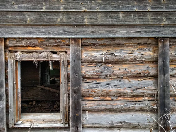 Das Fenster des alten Blockhauses auf dem Hintergrund der Holzwände — Stockfoto