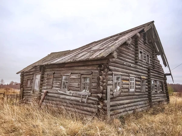 Una vieja desvencijada casa de madera de tronco residencial en ruinas . —  Fotos de Stock