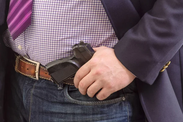 Closeup security agent in business suit with hand gun attached o