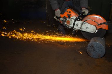 Closeup İşçi fabrika atölyesi elinde büyük bir dairesel testere ile metal testereler, kıvılcım