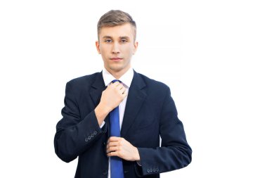 Genç ve çekici ciddi iş adamı açık mavi tiyi düzeltti