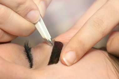 Profesyonel kaş düzeltme ameliyatı olan genç bir kadın. 