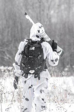 Beyaz kış kamuflaj bir keskin nişancı tüfeği ile bir avı kışın adam asker sahaya gider