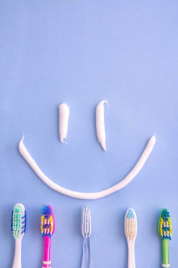 küçük diş macunu ve mavi üst görünümünden bir gülen gibi birkaç diş fırçası